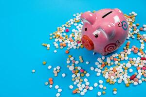 concept for medical expenses, Tablets and piggy bank on blue background photo