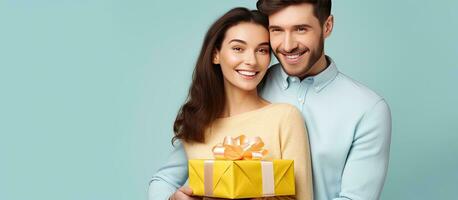 Happy couple friends in casual clothes pose with gift certificate on yellow wall background photo