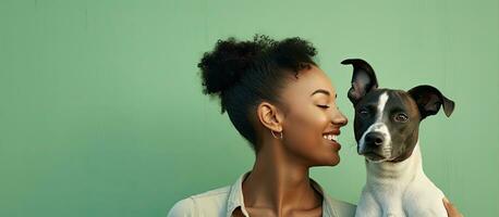 Young woman of African descent admires comical print of dog playfully emulates kissing gesture against light green backdrop Outdoor portrait of attractive photo