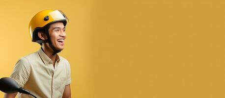 Asian online taxi driver on a motorbike smiling from the side isolated on a yellow background with room for text photo