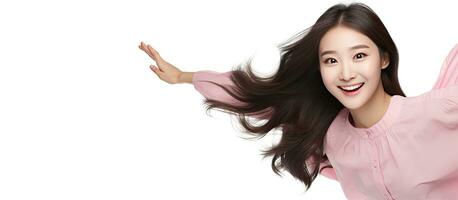 Smiling Asian girl floating in mid air pointing to empty space with a relaxed pose photo