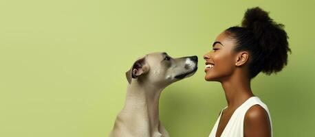 Young woman of African descent admires comical print of dog playfully emulates kissing gesture against light green backdrop Outdoor portrait of attractive photo