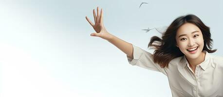 Smiling Asian girl floating in mid air pointing to empty space with a relaxed pose photo