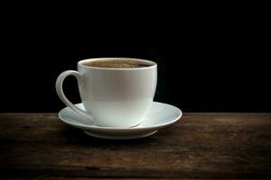 Cup of coffee on old wooden table photo