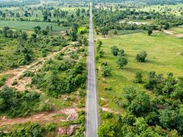 Aerial view road going through forest, Road through the green forest, Texture of forest view from above, Ecosystem and healthy environment concepts and background. photo