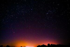 noche paisaje con vistoso y ligero amarillo lechoso camino lleno de estrellas en el cielo. foto