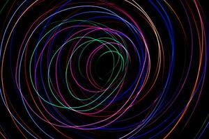 Multi color light painting photography, swirl and curve of blue, green and red light against a black background. photo