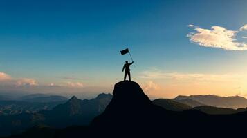 silhouette of businessman with flag on mountain top over sunset sky background, business, success, leadership and achievement concept. photo