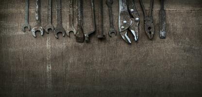 Old tools on wooden background. Old tools because they have been used long and hard. Banner background. photo