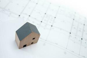 real estate and property, architecture, building, construction concept - Tiny house model on an architect's desk photo