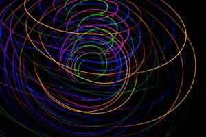 Multi color light painting photography, swirl and curve of blue, green and red light against a black background. photo