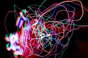 Multi color light painting photography, swirl and curve of blue, green and red light against a black background. photo