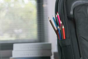 School supplies on wooden table in warm interior, school books on table, education concept. photo