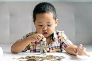 Preschooler child learning to calculate personal budget, manage finance, playing investment, accounting. Focused school kid saving money for purchase, putting cash in pink piggy bank at home. photo