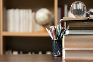 Education learning concept. Book in library with old open textbook, stack piles of literature text archive on reading desk, aisle of bookshelves in school study class room background for academic photo