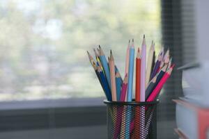 School supplies on wooden table in warm interior, school books on table, education concept. photo