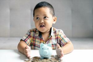 Preschooler child learning to calculate personal budget, manage finance, playing investment, accounting. Focused school kid saving money for purchase, putting cash in pink piggy bank at home. photo