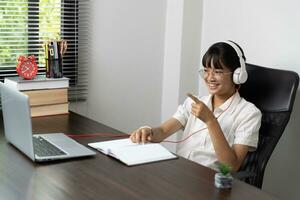 Student girl happy studying online, back to school concept. Young woman student busy study make notes in notebook and using laptop concentrated online training course technology education. photo