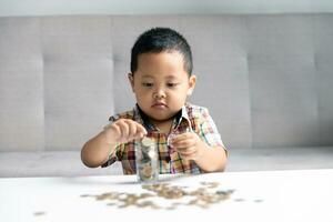 preescolar niño aprendizaje a calcular personal presupuesto, gestionar finanzas, jugando inversión, contabilidad. enfocado colegio niño ahorro dinero para compra, poniendo efectivo en rosado cerdito banco a hogar. foto