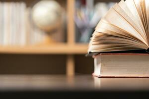 Education learning concept. Book in library with old open textbook, stack piles of literature text archive on reading desk, aisle of bookshelves in school study class room background for academic photo