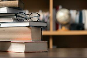 Education learning concept. Book in library with old open textbook, stack piles of literature text archive on reading desk, aisle of bookshelves in school study class room background for academic photo