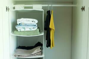 Children is wardrobe. Clothes in the closet. Clothes hang on hangers. Clothes on the shelves photo