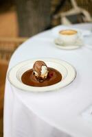 Brownie with ice cream and chocolate sauce. Brownie with raspberries. vertical photo