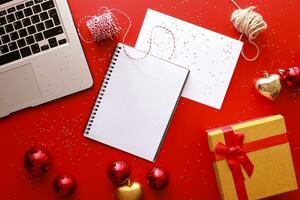 Flat lay christmas. Mockup notebook on a red background. Christmas toys photo