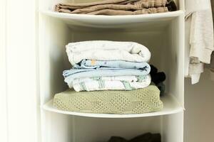 A stack of blankets in a childs closet. Muslin diapers. Kids things photo