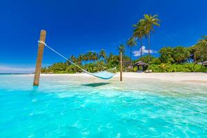 Tropical beach background as summer landscape with beach swing or hammock and white sand and calm sea for beach banner. Perfect beach scene vacation and summer holiday concept. Nature landscape photo