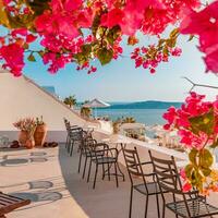 Amazing tranquil landscape of Santorini caldera and sea view, relaxing flowers, chaise lounge with white architecture. Fantastic summer scenic as vacation, travel holiday concept banner. Luxury vibes photo