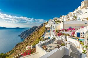 Amazing tranquil landscape of Santorini caldera and sea view, relaxing flowers, chaise lounge with white architecture. Fantastic summer scenic as vacation, travel holiday concept banner. Luxury vibes photo