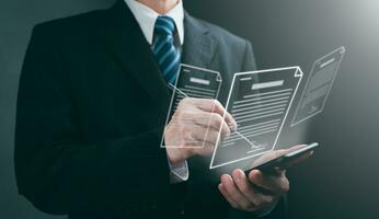 A businessman uses a stylus pen to sign electronic documents on digital documents on a virtual screen. E-signing, electronic signature, document management and paperless office concept. photo