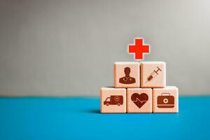 Healthcare, medical, insurance, hospital, clinic concept. Stacking Pyramid of health and medical icon on wooden block on blue background for health insurance, wellness, wellbeing, medical technology. photo