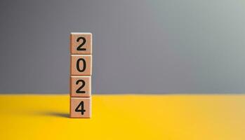 2024 New year goal planning idea concept, number in wooden block cubes. Gray and yellow background with copy space. photo