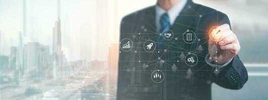 Businessman pointing a target icon on virtual screen with connection line and double exposure of city background. Business strategy and Action targeting, Planning the business concept. photo