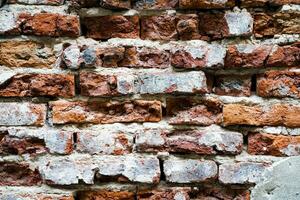 Outdoor Vintage Brickwall With Damaged Plaster. Grungy Stone Wall Rectangular Surface. Old Grungy Brickwork Horizontal Texture. photo