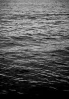 Reflect ripple water texture background. High resolution wallpaper of dark water. Abstract surface sea water in black and white photography. photo