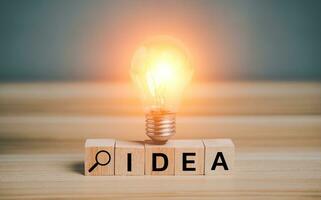 idea concepto creativo, inspiración. idea texto en bosque bloquear con iluminado ligero bulbo, innovación, pensamiento, tecnología concepto. creatividad, brillar bombillas, solución, estrategia, nuevo ideas, imaginación. foto