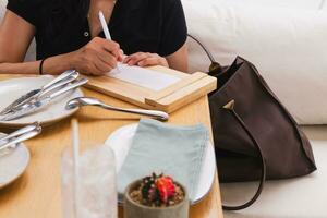 Woman signing slip payment credit card at dinner tale in restaurant. photo