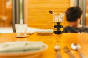 A glass bottle with olive oil and balsamic vinegar on dinner table. photo