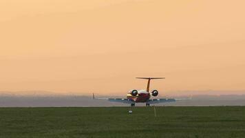 privat jet ankomst på solnedgång. flygplan bromsning efter landning. höja klaffar när bromsning. flygplan silhuett på solnedgång bakgrund video