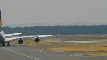 posterior ver de un enorme amplio cuerpo avión de línea en el calle de rodaje largo disparo, pasajero avión que se acerca para aterrizaje. tráfico a el aeropuerto. turismo y viaje concepto video