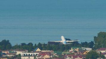 SOCHI, RUSSIA JULY 29, 2022 - Boeing 737 Pobeda Airlines taking off from Sochi airport. Airplane climb over the sea, rear view. Tourism and travel concept video