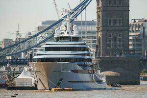 Cruise ship moored on Thames river with Tower bridge in background photo