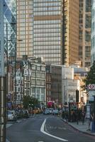 Vehicles moving on road amidst office buildings in financial city of London photo