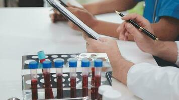 Health care researchers working in life science laboratory. Young female research scientist and senior male supervisor preparing and analyzing microscope slides in research lab. video