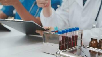 Health care researchers working in life science laboratory. Young female research scientist and senior male supervisor preparing and analyzing microscope slides in research lab. video