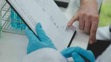 Health care researchers working in life science laboratory. Young female research scientist and senior male supervisor preparing and analyzing microscope slides in research lab. video