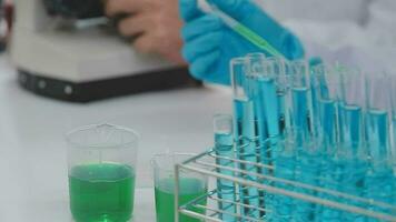 Health care researchers working in life science laboratory. Young female research scientist and senior male supervisor preparing and analyzing microscope slides in research lab. video